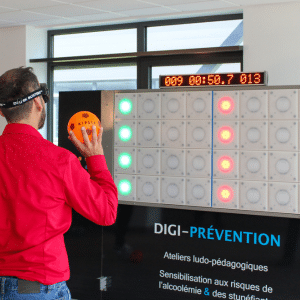 collaborateur expérimentant le mur digital interactif pour tester ses réflexes liés à la consommation d'alcool et drogues sur la route